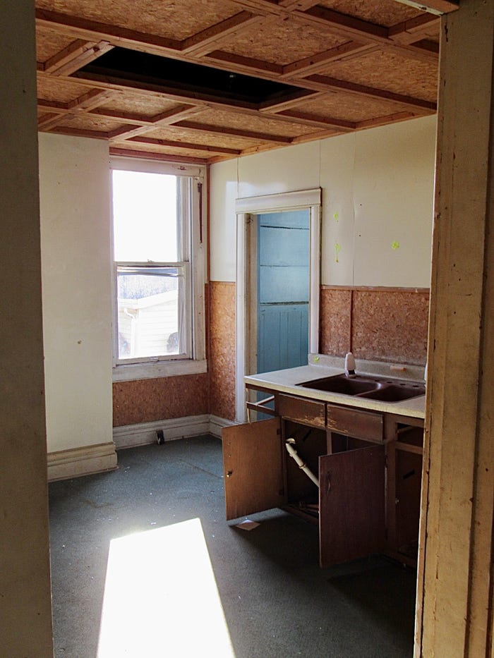 An outdated kitchen with a broken sink