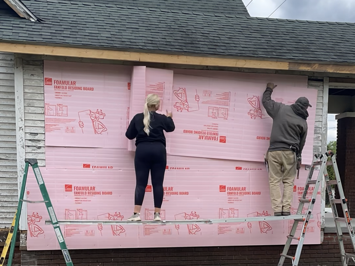 Katie and her father installing siding.